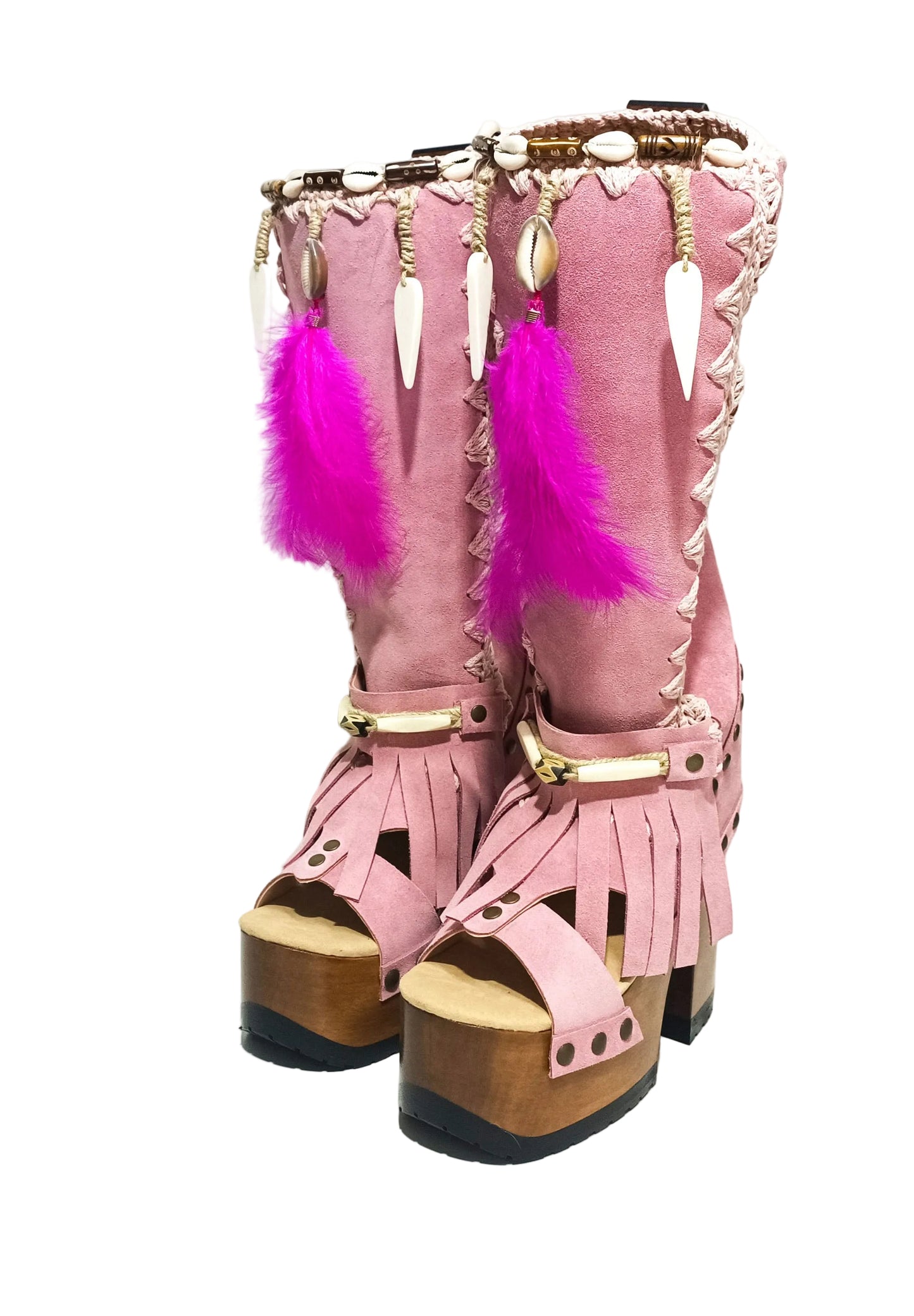 Close-up of Rhapsody Bohemia Pink Boots in premium pink suede with fringe, hand-selected feathers, and organic shells. These artisanal boho boots by Sol Caleyo feature a high hand-sculpted wooden heel and platform.