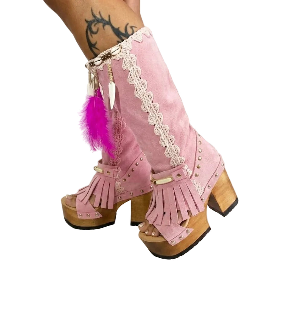 Close-up of Rhapsody Bohemia Pink Boots in premium pink suede with fringe, hand-selected feathers, and organic shells. These artisanal boho boots by Sol Caleyo feature a high hand-sculpted wooden heel and platform.