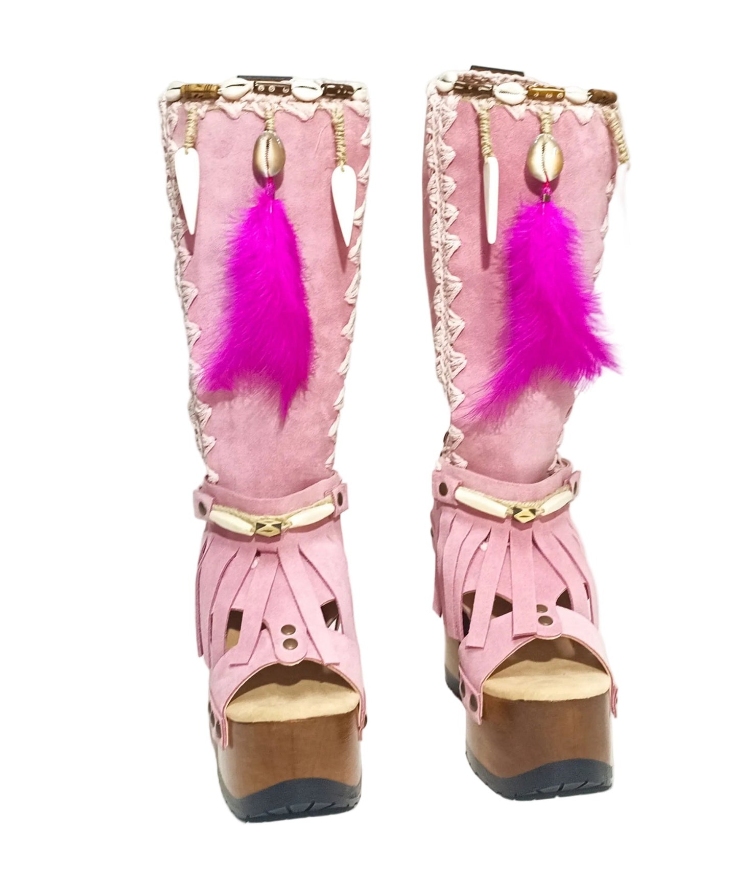 Close-up of Rhapsody Bohemia Pink Boots in premium pink suede with fringe, hand-selected feathers, and organic shells. These artisanal boho boots by Sol Caleyo feature a high hand-sculpted wooden heel and platform.