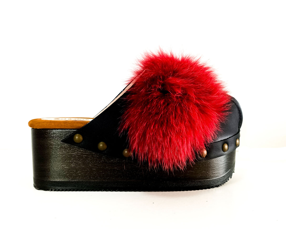 Handmade black leather open-back wedge mule clogs with bordeaux fur panels, gold studs and 6 cm wooden wedge by Sol Caleyo.