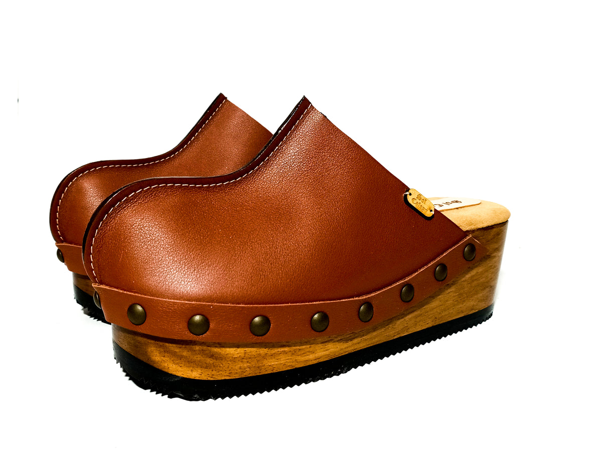 Brown handmade leather wedge mule clogs with old-gold studs and wooden wedge sole by Sol Caleyo