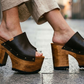 Dark brown wide strap platform mule sandals with antique-gold studs, styled with linen trousers, made to order by Sol Caleyo