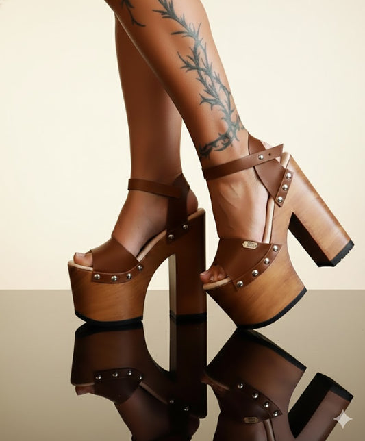 Ankle strap on brown leather platform sandals, Decorative side studs close-up, Lacquered wooden platform 17 cm heel, Goatskin suede cushioned insole.