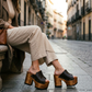 Handmade dark brown leather platform mule sandals with a 13 cm wooden heel, worn on a city street, by Sol Caleyo