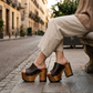 Brown leather platform mules on a lacquered wooden sole, worn by a model, 100% handmade to order