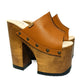 Handmade full-grain camel leather open toe platform mule sandals with wide strap, round flat old-gold studs and 17 cm natural lacquered wooden heel by Sol Caleyo.