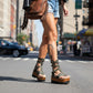 Handmade military green and brown camo print leather gladiator wedge flip flop sandals with three old-gold buckles, pyramid studs and 8.5 cm natural lacquered wooden wedge by Sol Caleyo. 
