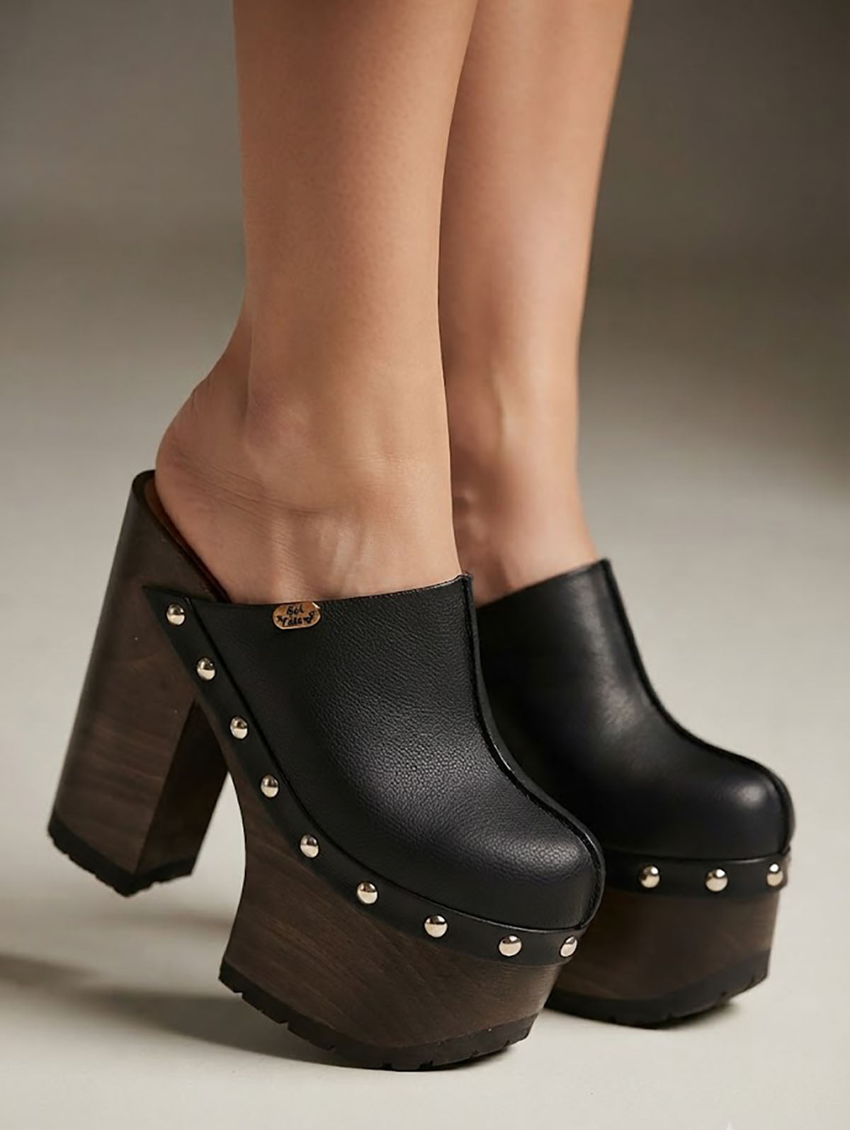 Sol Caleyo handmade black leather platform clogs with wenge wood heel and silver stud detailing being worn.
