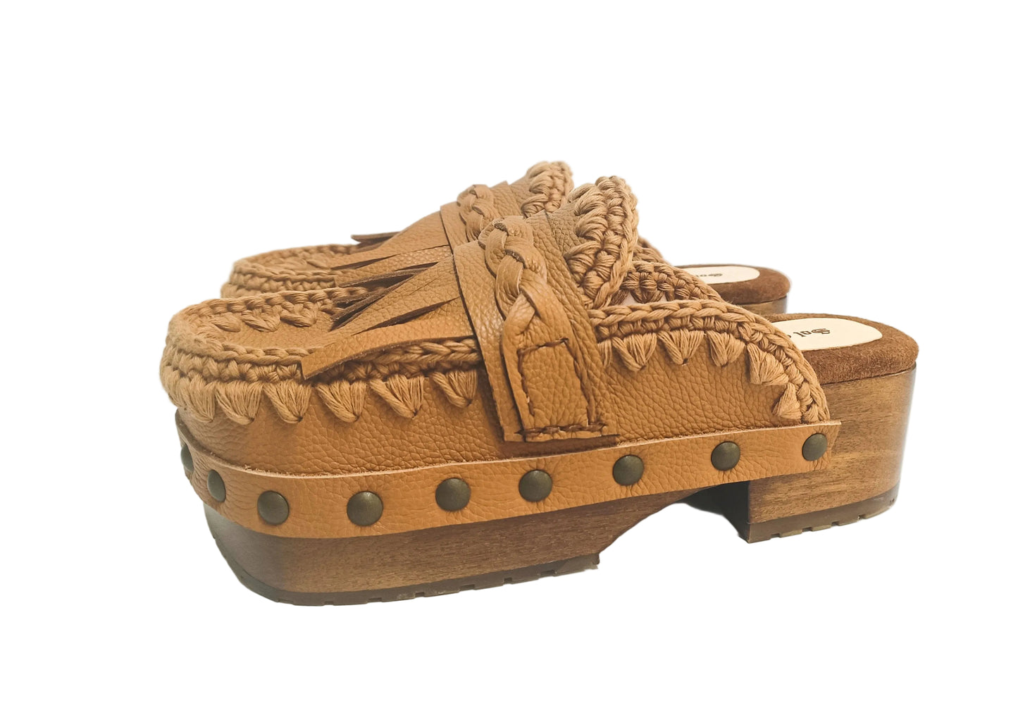 Side profile of Sol Caleyo Niza Clogs in light brown leather, showcasing hand-braided strap, crochet trim, bronze studs, and a sturdy wooden platform sole.