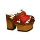 Verona Clogs by Sol Caleyo featuring light brown cow hair leather, red fringe details, and old gold studs on a high wooden platform sole with tractor grip.
