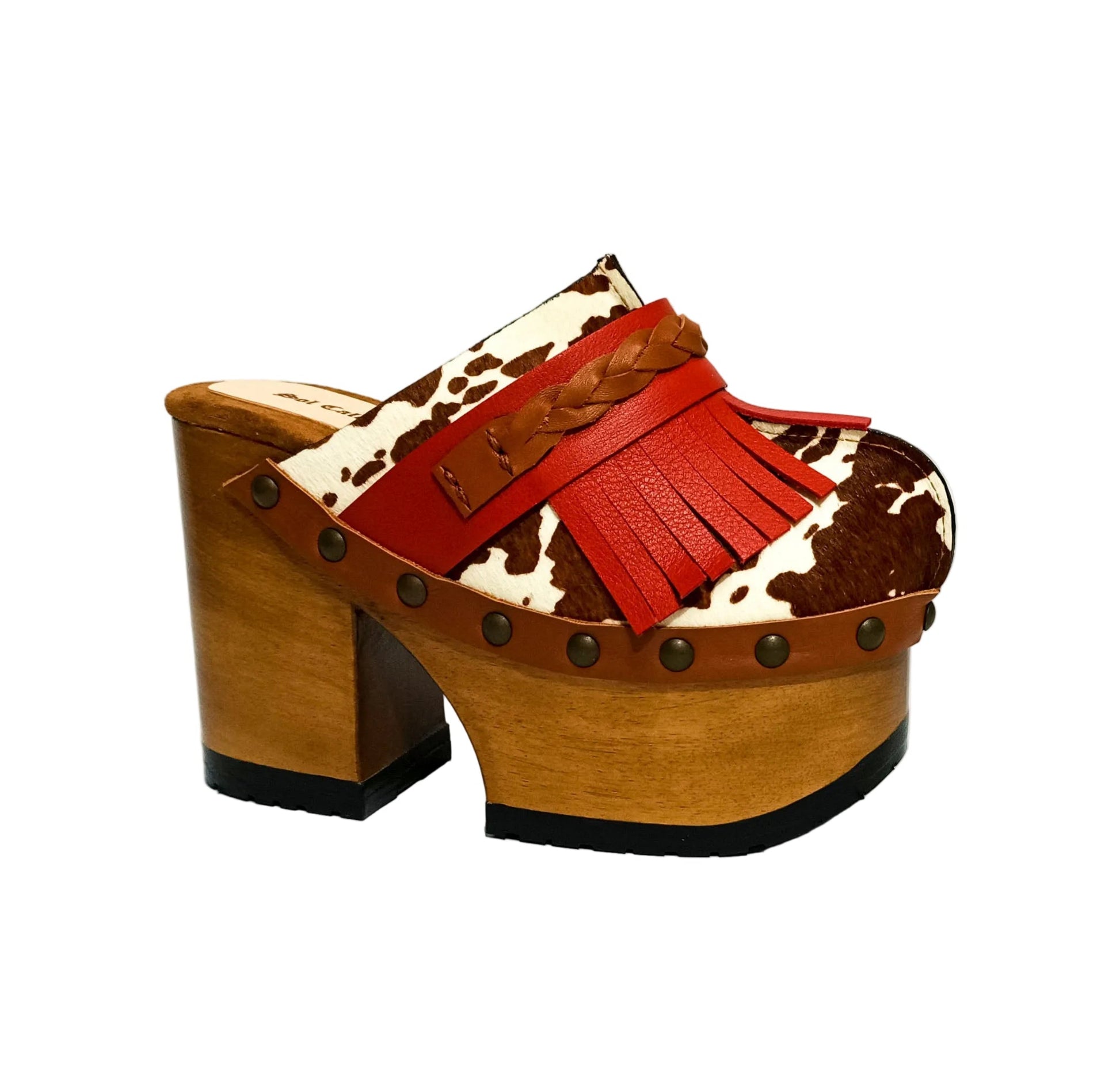Verona Clogs by Sol Caleyo featuring light brown cow hair leather, red fringe details, and old gold studs on a high wooden platform sole with tractor grip.