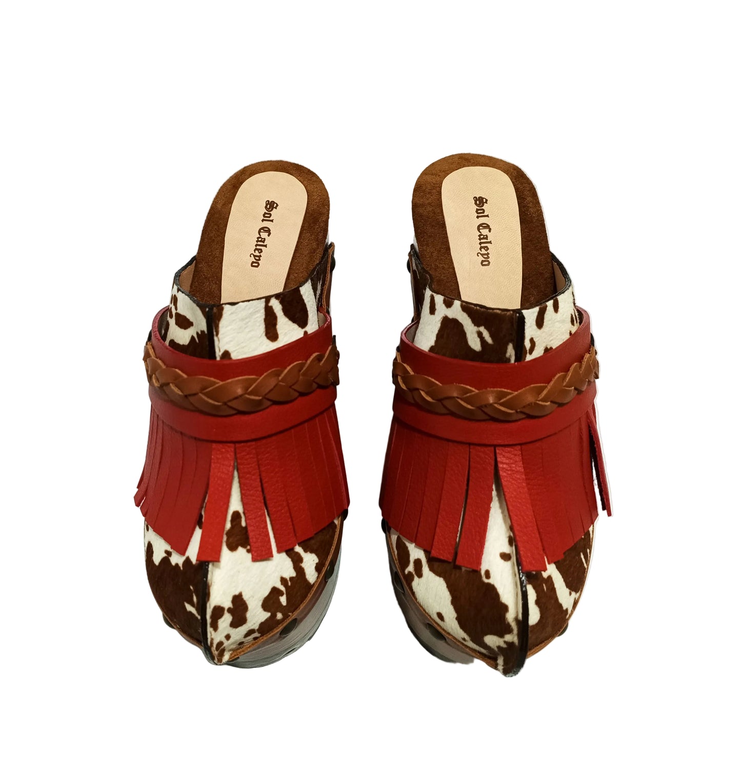 Verona Clogs by Sol Caleyo featuring light brown cow hair leather, red fringe details, and old gold studs on a high wooden platform sole with tractor grip.