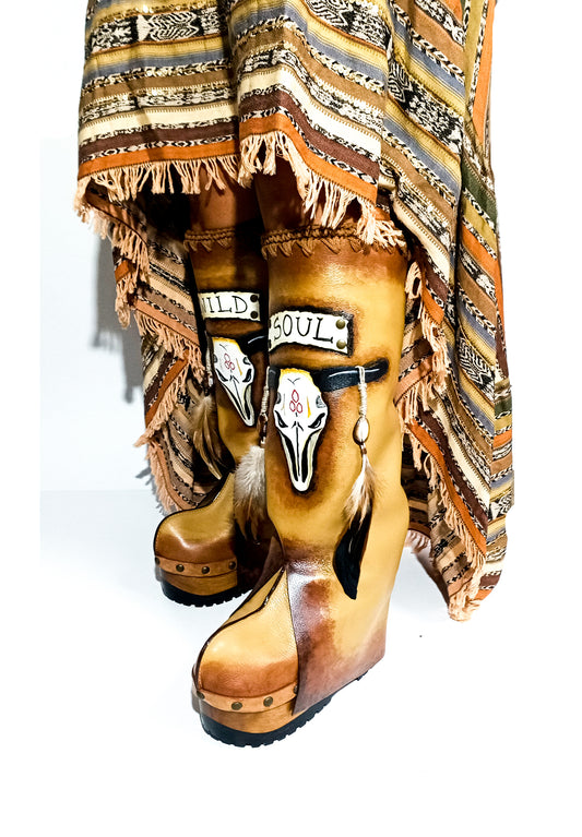 Leather clog boot with wooden wedge. Leather boot with hand painted buffalo decorated with shells and feathers. Leather boot with wooden wedge in antique beige leather. Wooden wedge boot in far west style. Bohemian style leather boot. Sizes 34 to 47. High quality leather footwear handmade by sol Caleyo. Sustainable fashion.