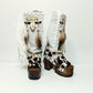 Handmade cowboy boots, white boots with cowhide and fringes. Cowboy style boots with hand painted buffalo, feathers, coins and natural shells. Vintage style platform boots. High-end leather footwear handmade by Sol Caleyo.