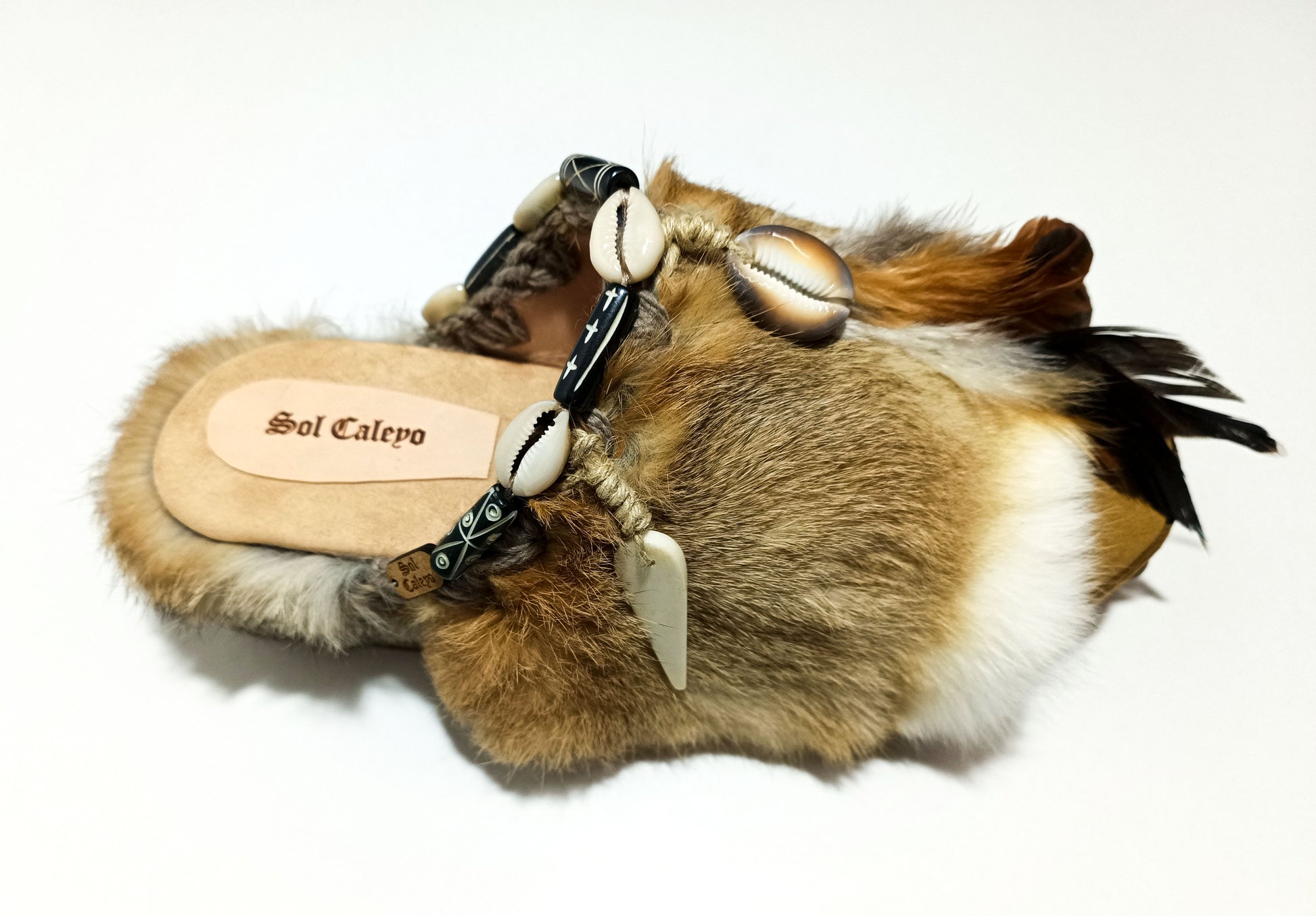 Platform clogs made of leather and rabbit fur, decorated with horns, shells and feathers for a bohemian style. Sizes 34 to 47. The Viking Clogs are an exclusive design by Sol Caleyo.