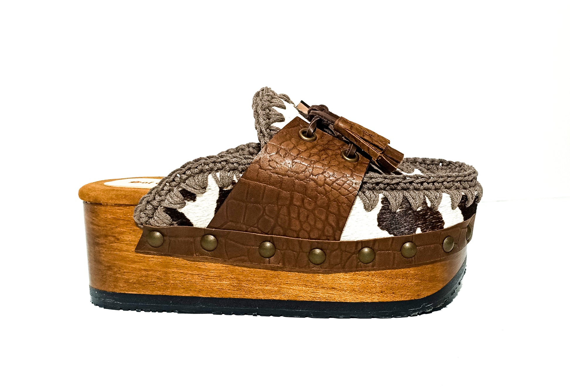 Moccasin style cowhide leather clogs, decorated with fringed laces. Moccasin style leather mules. High-end footwear handmade by Sol Caleyo.