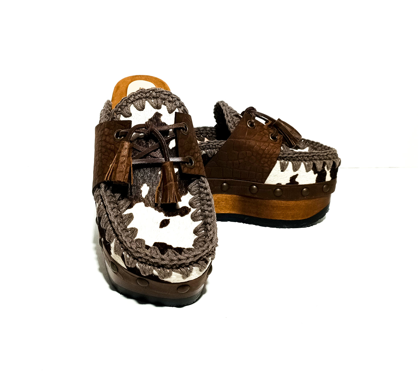 Moccasin style cowhide leather clogs, decorated with fringed laces. Moccasin style leather mules. High-end footwear handmade by Sol Caleyo.