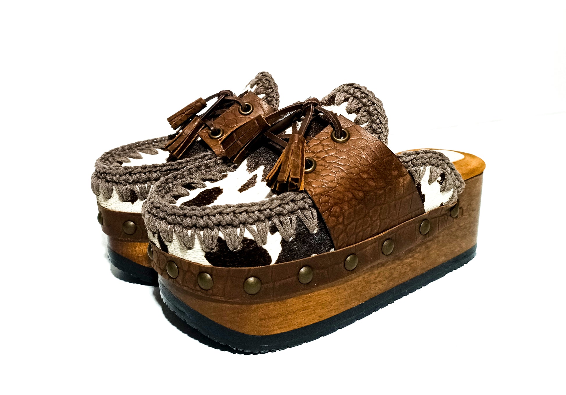 Moccasin style cowhide leather clogs, decorated with fringed laces. Moccasin style leather mules. High-end footwear handmade by Sol Caleyo.