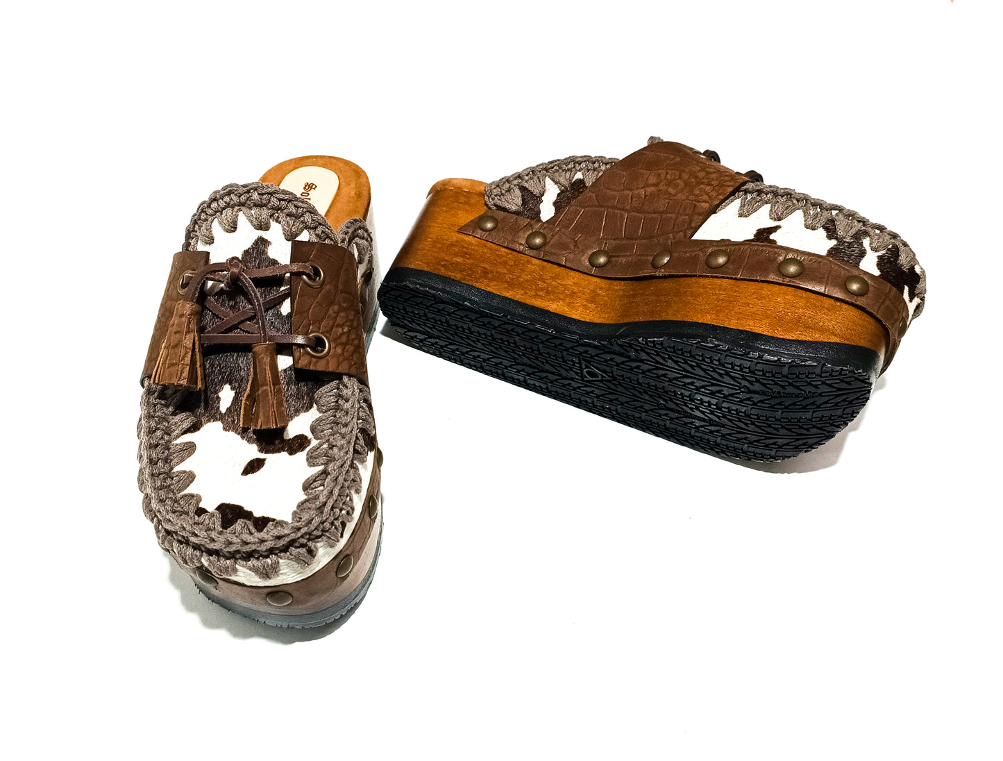 Moccasin style cowhide leather clogs, decorated with fringed laces. Moccasin style leather mules. High-end footwear handmade by Sol Caleyo.