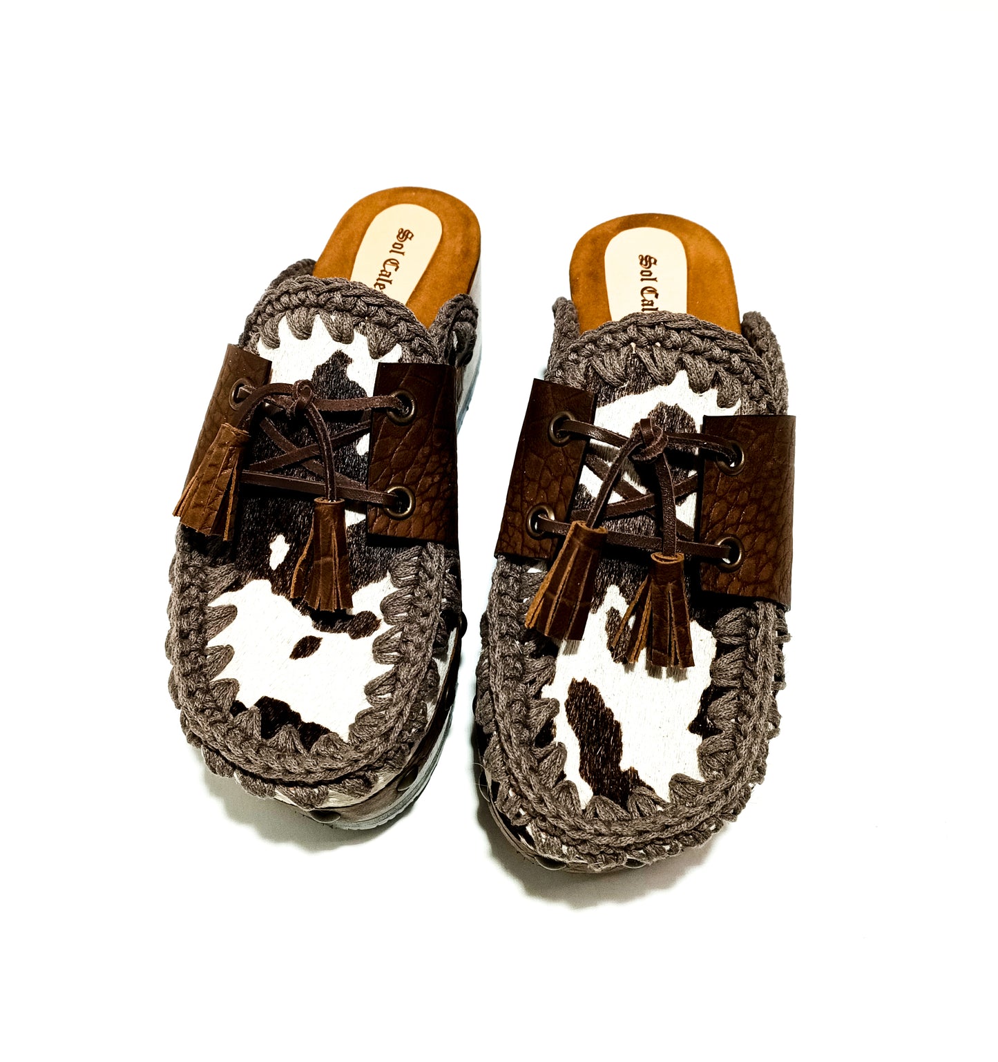 Moccasin style cowhide leather clogs, decorated with fringed laces. Moccasin style leather mules. High-end footwear handmade by Sol Caleyo.