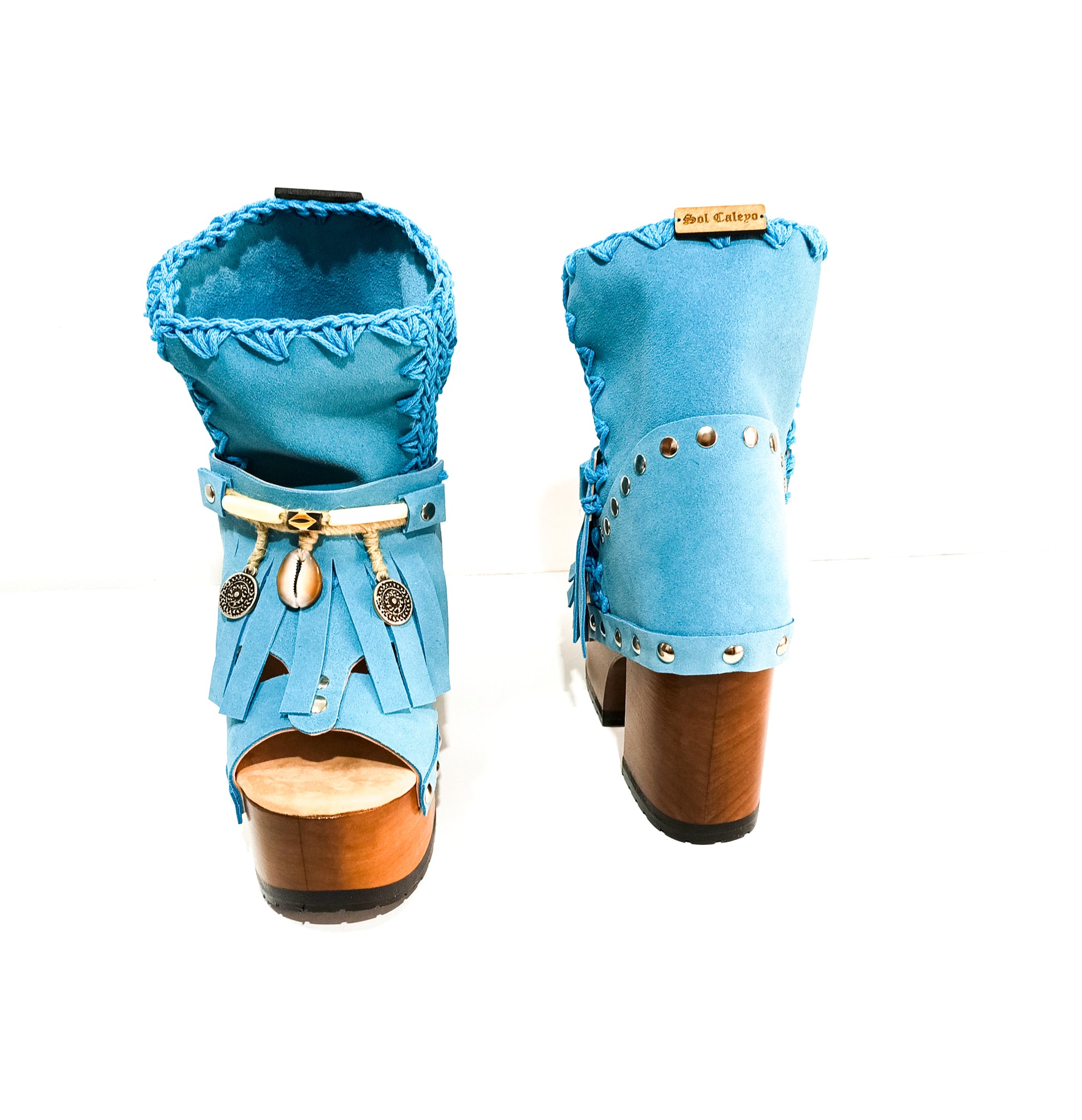 Bohemian style turquoise suede leather boots. Turquoise boots with wooden heel. Turquoise boots decorated with coins, horns and feathers, Boho Chic style. High-end handmade footwear by Sol Caleyo.