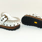 White wooden wedge clogs. White leather mules. Oxford style buckle clogs. High quality handmade shoes by Sol Caleyo.
