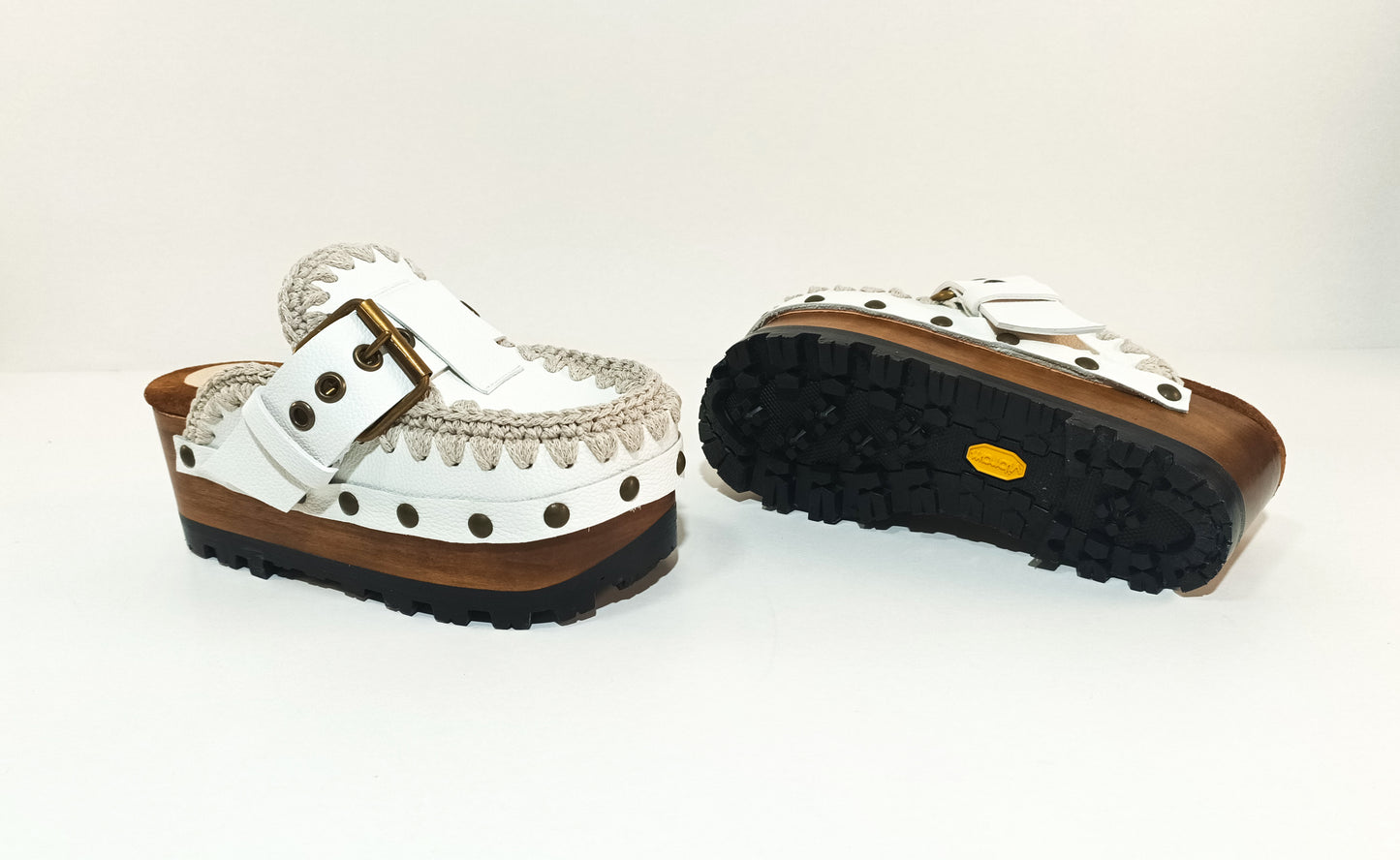 White wooden wedge clogs. White leather mules. Oxford style buckle clogs. High quality handmade shoes by Sol Caleyo.
