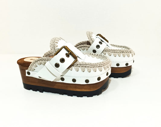 White wooden wedge clogs. White leather mules. Oxford style buckle clogs. High quality handmade shoes by Sol Caleyo.
