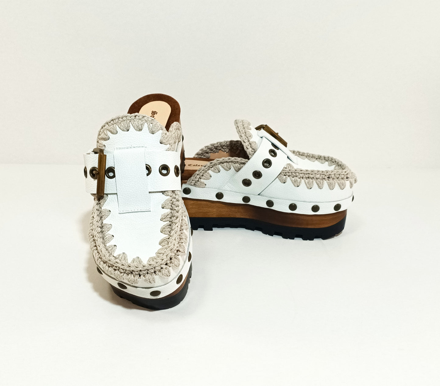 White wooden wedge clogs. White leather mules. Oxford style buckle clogs. High quality handmade shoes by Sol Caleyo.