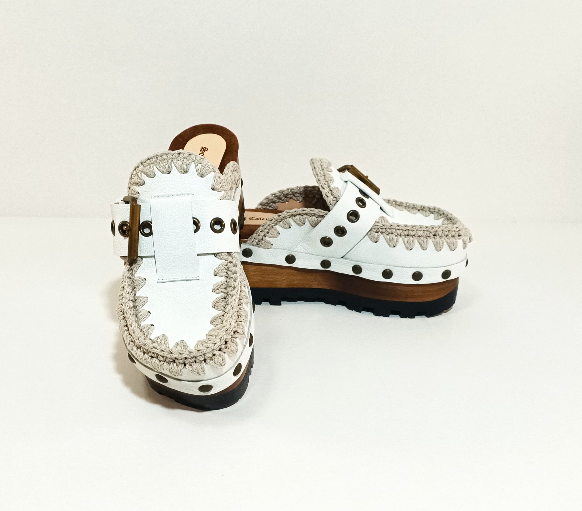 White wooden wedge clogs. White leather mules. Oxford style buckle clogs. High quality handmade shoes by Sol Caleyo.