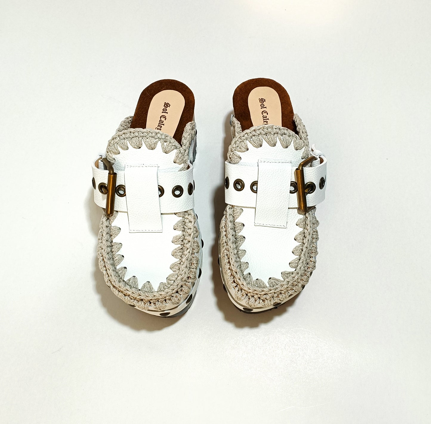 White wooden wedge clogs. White leather mules. Oxford style buckle clogs. High quality handmade shoes by Sol Caleyo.
