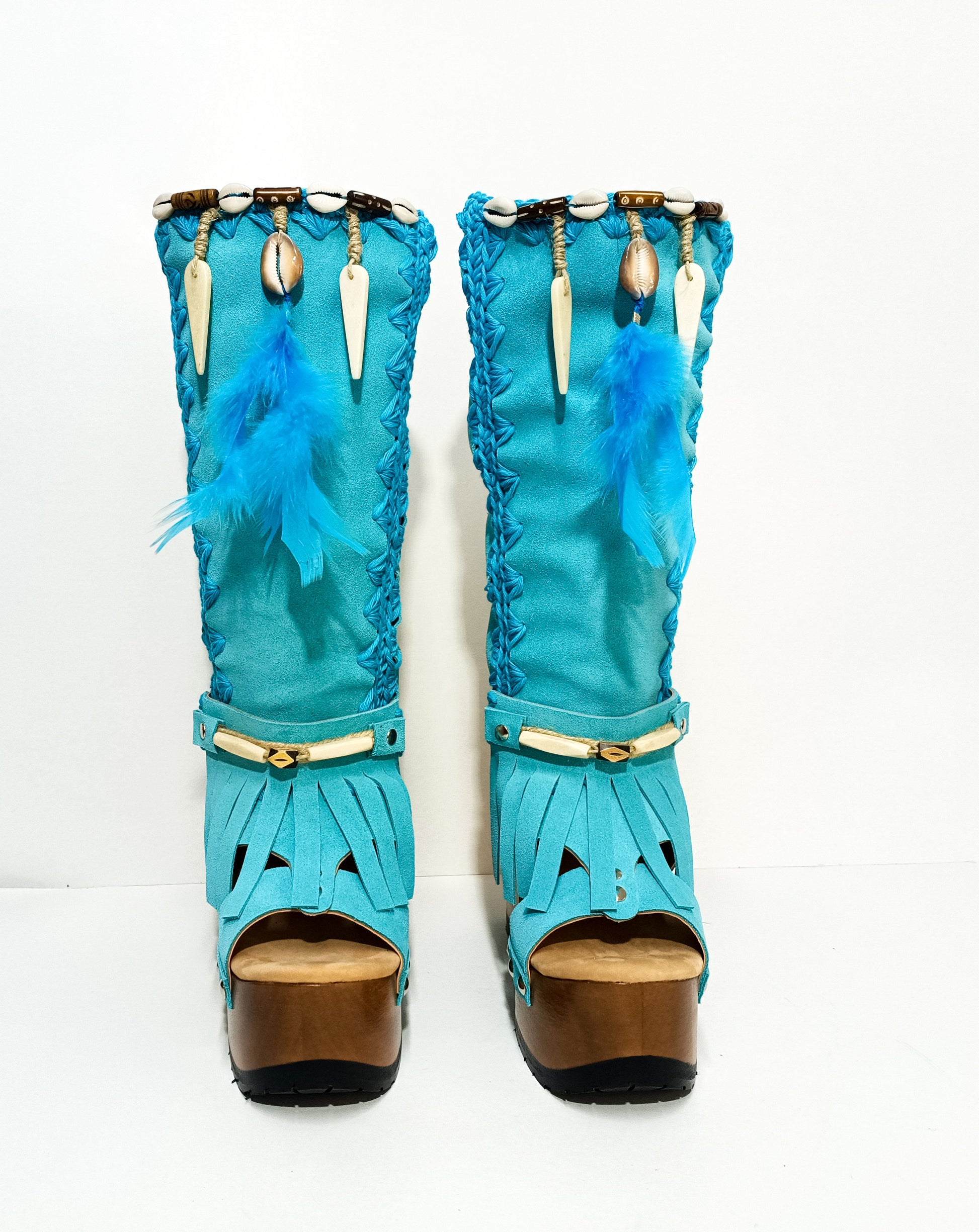Turquoise bohemian-style boots, handmade. Platform boots with wooden heel. Turquoise bohemian-style boots decorated with feathers, shells and carved bone. High-end footwear handmade by Sol Caleyo.