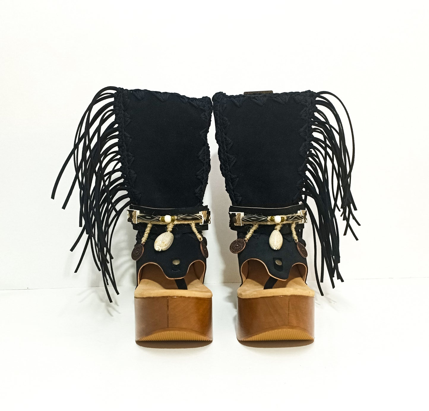 Leather clog boot with wooden wedge flip flop style. Leather flip flop style boot decorated with shells, coins and fringes which gives it an authentic Boho style. Leather flip flop with wooden wedge. Bohemian style leather boot. Sizes 34 to 47. High quality leather footwear handmade by sol Caleyo. Sustainable fashion.