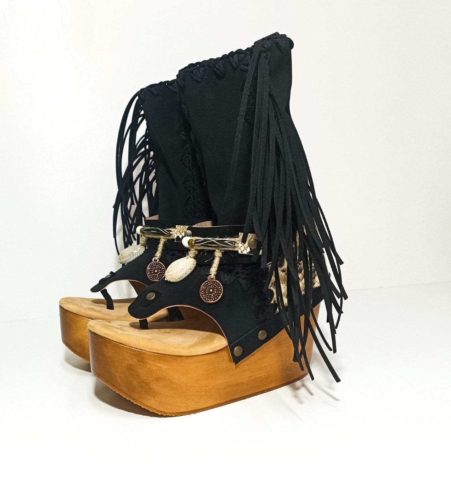 Leather clog boot with wooden wedge flip flop style. Leather flip flop style boot decorated with shells, coins and fringes which gives it an authentic Boho style. Leather flip flop with wooden wedge. Bohemian style leather boot. Sizes 34 to 47. High quality leather footwear handmade by sol Caleyo. Sustainable fashion.