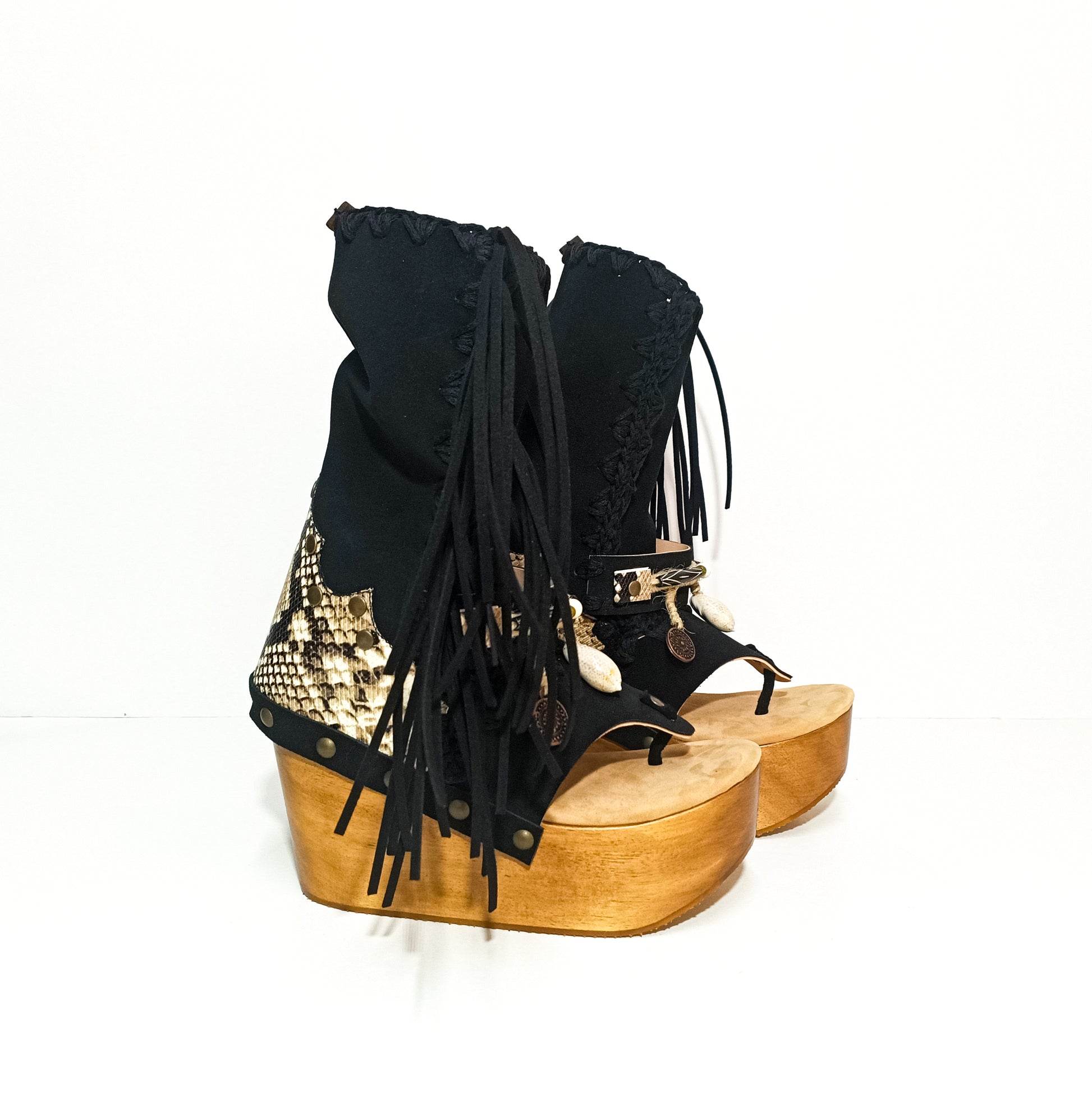 Leather clog boot with wooden wedge flip flop style. Leather flip flop style boot decorated with shells, coins and fringes which gives it an authentic Boho style. Leather flip flop with wooden wedge. Bohemian style leather boot. Sizes 34 to 47. High quality leather footwear handmade by sol Caleyo. Sustainable fashion.