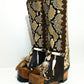 Detail of boho embellishments on handmade snake leather boots including feathers, shells and carved horn