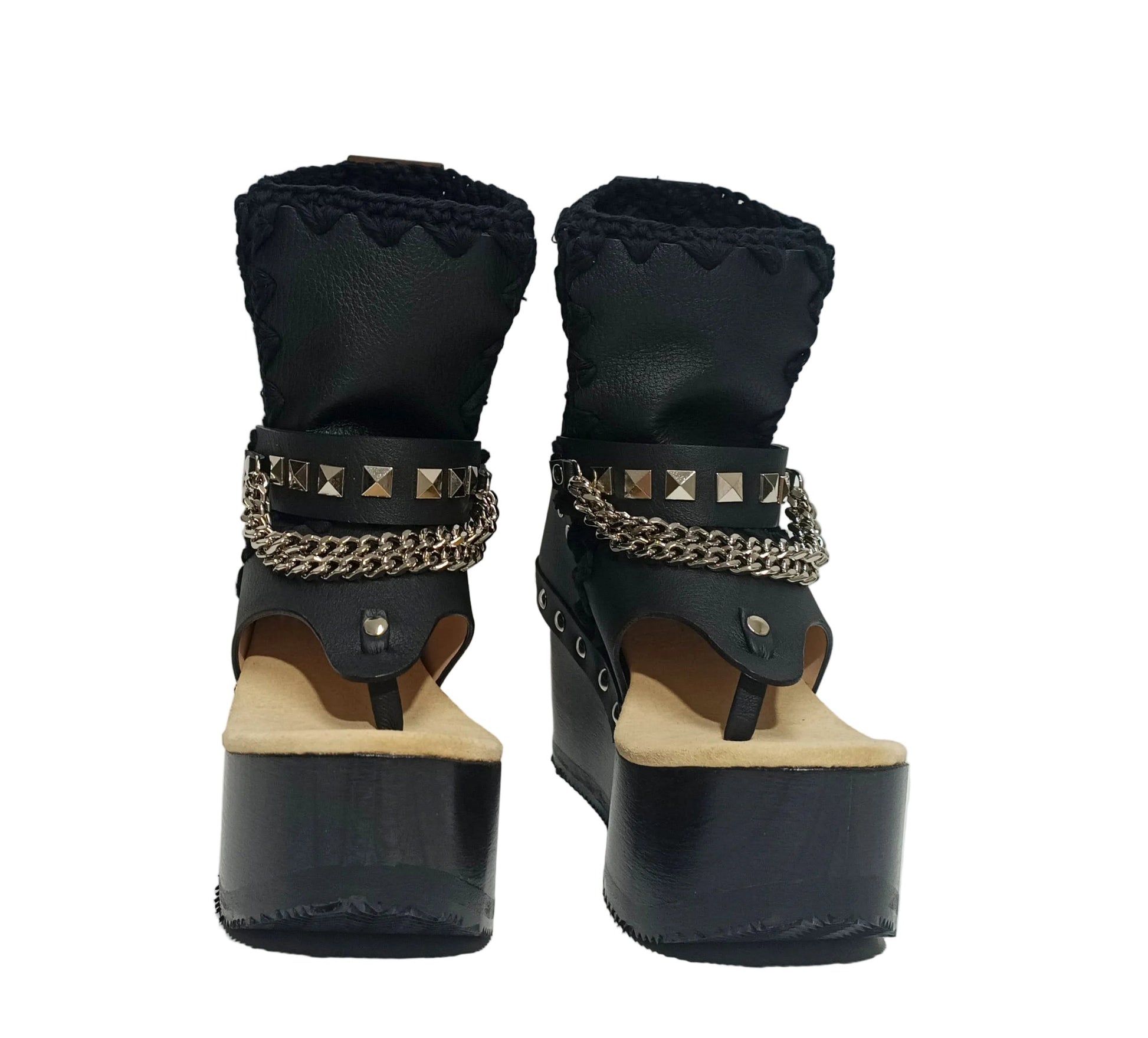 Sol Caleyo Texas Boots: Handcrafted black leather platform flip-flop sandals with wooden wedge heel, silver pyramid studs, and decorative chains. 9cm heel with zig-zag rubber traction sole.
