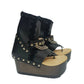 Sol Caleyo Texas Boots: Handcrafted black leather platform flip-flop sandals with wooden wedge heel, silver pyramid studs, and decorative chains. 9cm heel with zig-zag rubber traction sole.