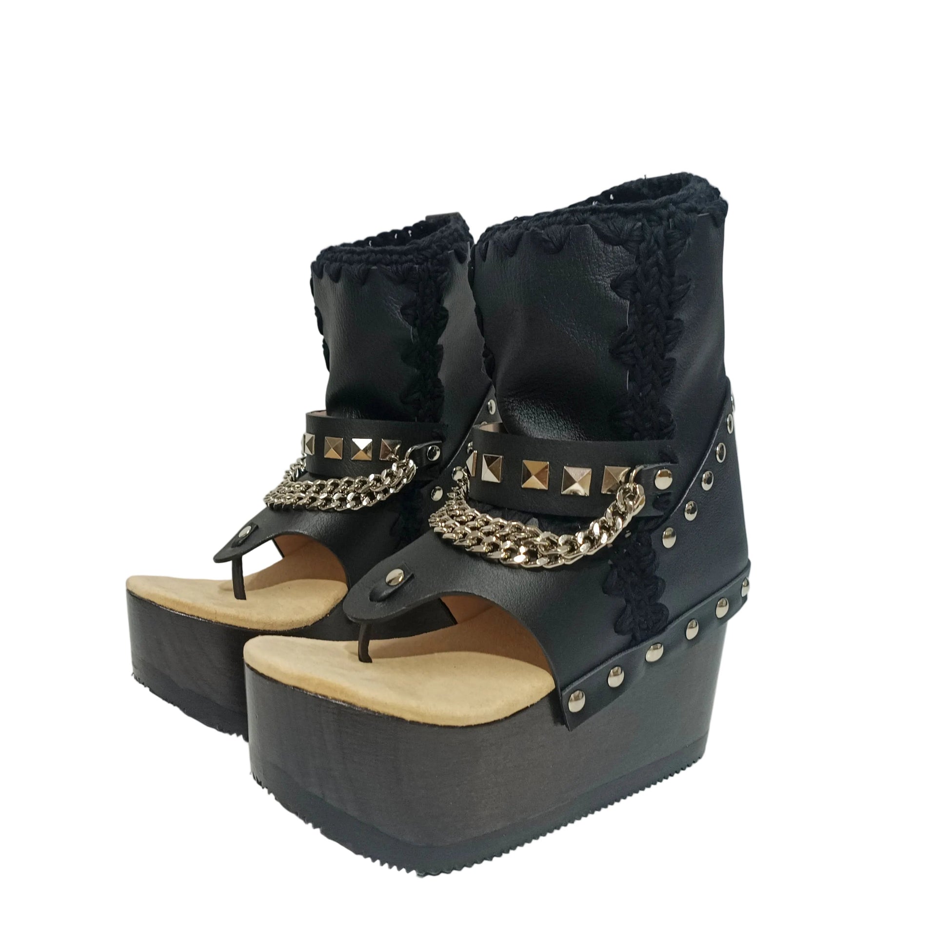 Sol Caleyo Texas Boots: Handcrafted black leather platform flip-flop sandals with wooden wedge heel, silver pyramid studs, and decorative chains. 9cm heel with zig-zag rubber traction sole.