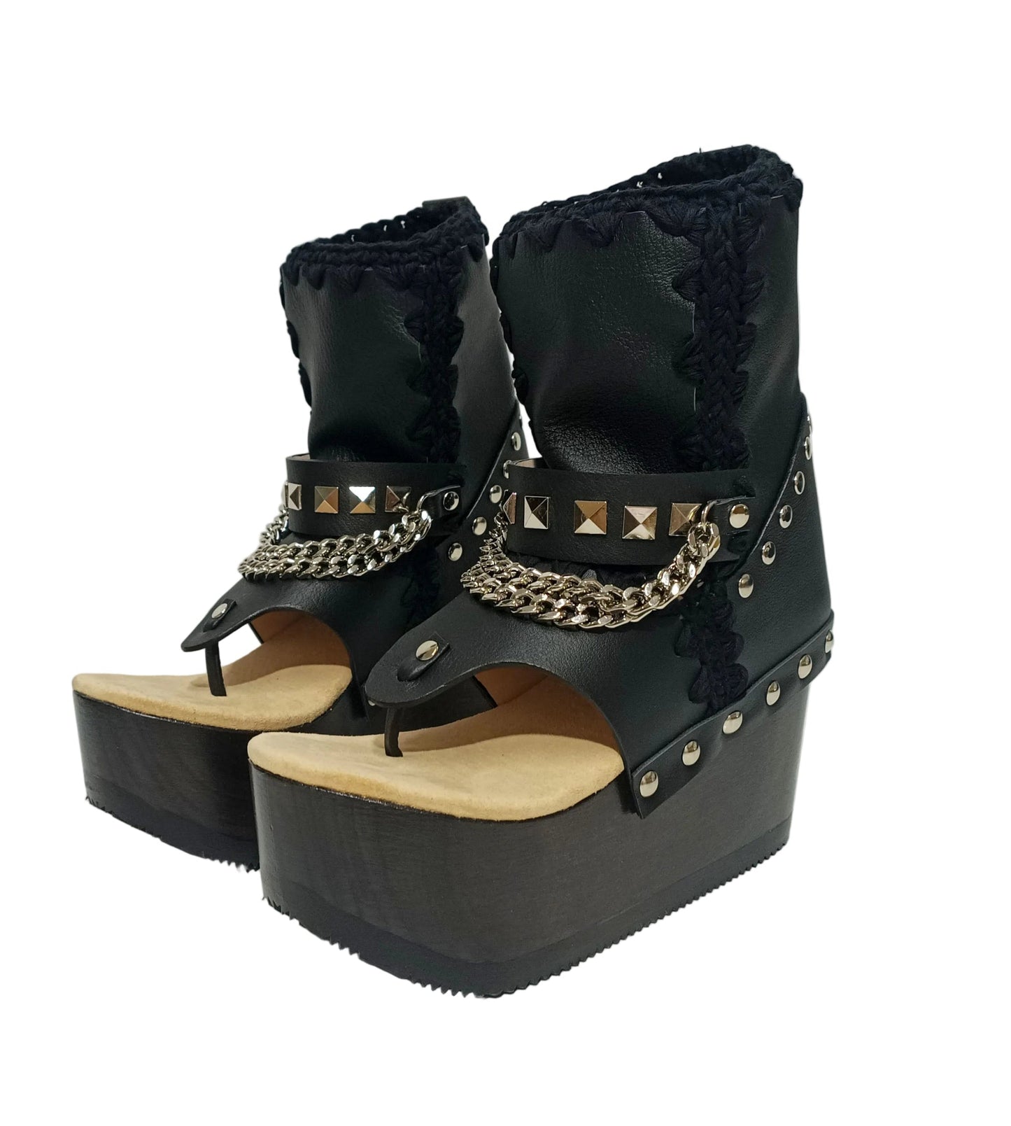 Sol Caleyo Texas Boots: Handcrafted black leather platform flip-flop sandals with wooden wedge heel, silver pyramid studs, and decorative chains. 9cm heel with zig-zag rubber traction sole.