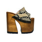 Handcrafted Snake Luxury Queen Sandals by Sol Caleyo featuring exotic snake-print leather, 17cm bell heel, and 11cm hand-carved wooden platform on a white background.