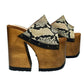 Handcrafted Snake Luxury Queen Sandals by Sol Caleyo featuring exotic snake-print leather, 17cm bell heel, and 11cm hand-carved wooden platform on a white background.