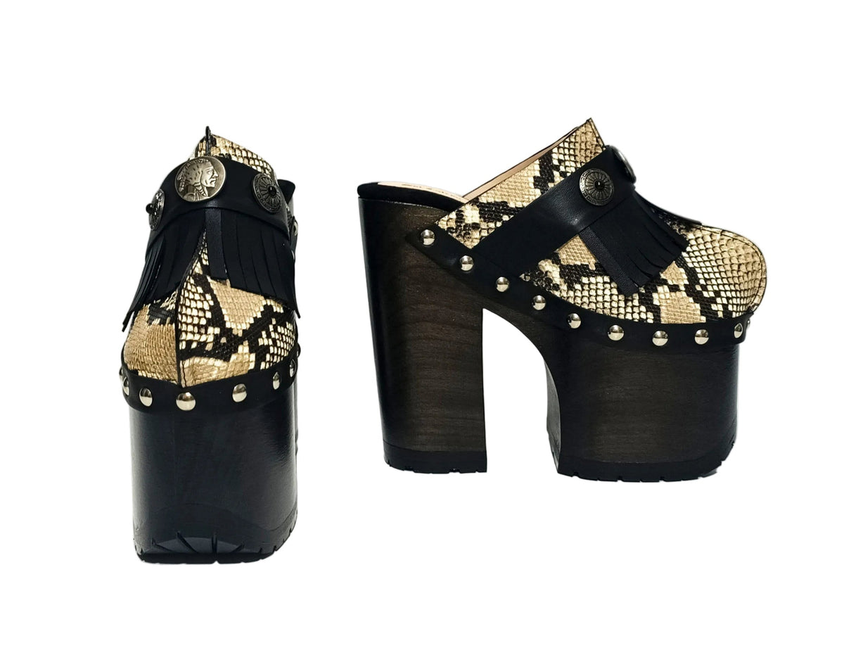 Indian Snake Clogs by Sol Caleyo: extreme 18cm straight heel wooden platforms with snake-print leather, black fringe, and Native American style metal conchos.