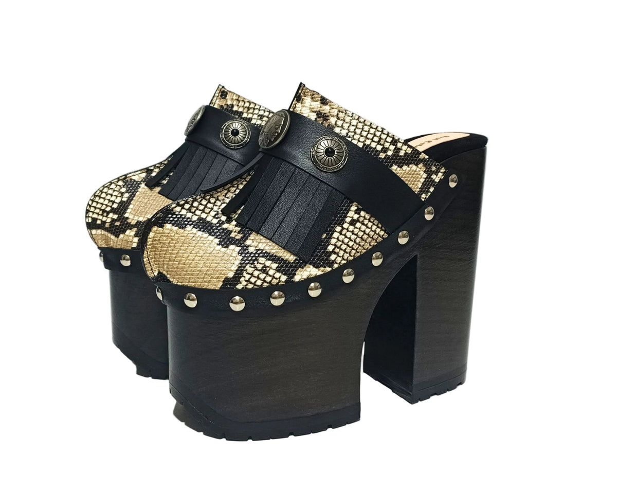 Indian Snake Clogs by Sol Caleyo: extreme 18cm straight heel wooden platforms with snake-print leather, black fringe, and Native American style metal conchos.