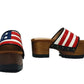 American Sandals XS by Sol Caleyo: close-up of handmade wooden platform sandals with USA flag leather strap and studs.