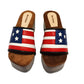 American Sandals XS by Sol Caleyo: close-up of handmade wooden platform sandals with USA flag leather strap and studs.
