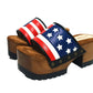 American Sandals XS by Sol Caleyo: close-up of handmade wooden platform sandals with USA flag leather strap and studs.