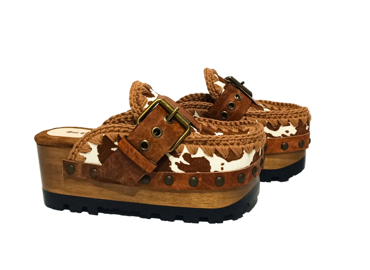 Oxford Clogs Cowhide Print by Sol Caleyo: handmade wooden platform clogs with cowhide hair-on leather, crochet trim, and aged camel leather strap.