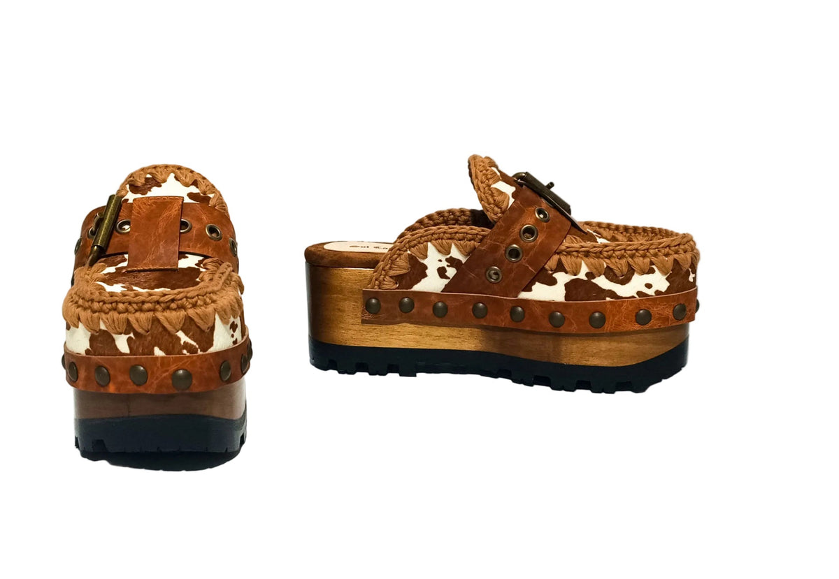 Oxford Clogs Cowhide Print by Sol Caleyo: handmade wooden platform clogs with cowhide hair-on leather, crochet trim, and aged camel leather strap.
