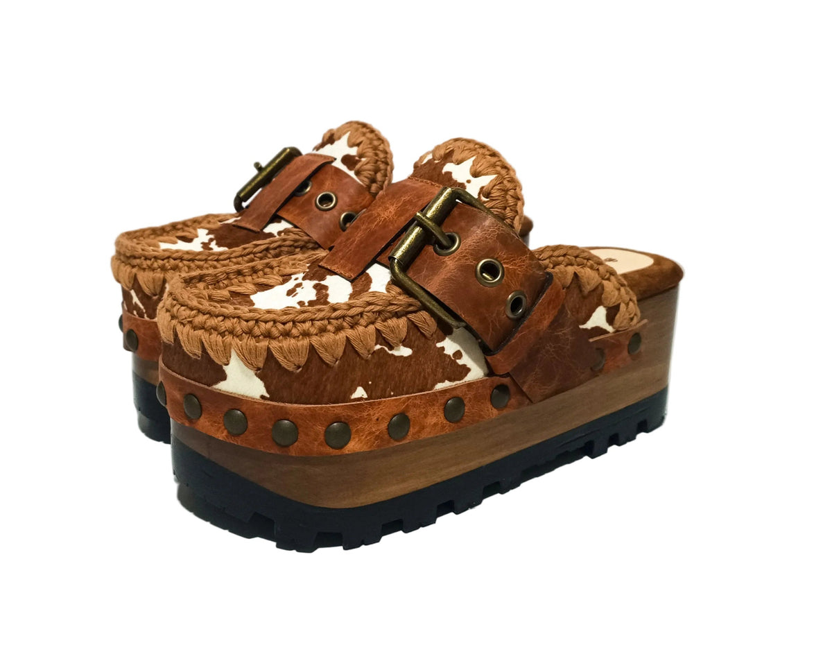 Oxford Clogs Cowhide Print by Sol Caleyo: handmade wooden platform clogs with cowhide hair-on leather, crochet trim, and aged camel leather strap.
